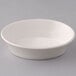 A Tuxton eggshell china oval baker bowl on a white surface