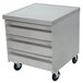 An Advance Tabco grey metal cabinet with three drawers and wheels.