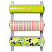A Bulman wall rack holding rolls of colorful wrapping paper.