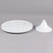 An Elite Global Solutions faux Carrara marble round plate stand holding a white plate on a gray surface.