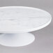 An Elite Global Solutions faux Carrara marble round cake plate stand.