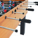 An American Legend foosball table with soccer balls on it.