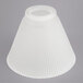 A white pleated lamp shade on a gray surface.