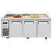 A white Turbo Air refrigerated buffet display table with three trays of food inside.