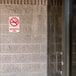 A Thunder Group red and white no smoking sign on a door.