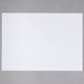 A white paper sheet with straight edges on a gray surface.