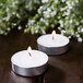 Two Leola tea light candles burning on a table.