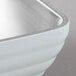 A Vollrath stainless steel bowl with a white beehive design and silver rim.