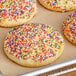 A close up of a cookie with Rainbow Nonpareils on top.
