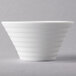 An Arcoroc white porcelain bowl with a curved design.