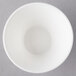 An Arcoroc spiral porcelain bowl on a gray surface.