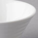 A close up of a white Arcoroc spiral porcelain bowl with a white rim.