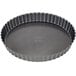A round metal quiche pan with a scalloped edge and a removable round bottom.