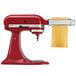 A white KitchenAid Artisan stand mixer with a KitchenAid pasta roller attachment on it.