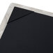 A Menu Solutions Alumitique aluminum single panel menu board with picture corners on a black table.