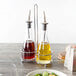 A table set with a Tablecraft chrome plated oil and vinegar bottle pourer on a farm-to-table restaurant table.