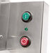 A close up of a Doyon dough sheeter with a stainless steel door and two buttons, one green and one red.