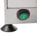 The stainless steel metal surface of a Doyon countertop dough sheeter with round green buttons.