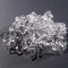 A pile of flake ice from a Hoshizaki undercounter ice machine on a black surface.