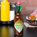 A bottle of TABASCO® Chipotle Pepper Hot Sauce on a table.
