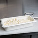 A white Cambro 1/3 size plastic food pan with cottage cheese in it.
