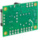 A green Accutemp low water control circuit board with yellow and green circles and small round holes.