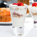 A Libbey tall shot glass filled with yogurt, strawberries, and granola.
