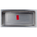 A rectangular stainless steel tray with a red label.