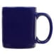 A close-up of a Tuxton cobalt blue coffee mug with a handle.