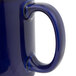 A close-up of a blue Tuxton china mug with a handle.