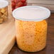 A clear Cambro plastic container with shredded cheese inside.