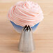 A cupcake with pink frosting piped on top using an Ateco closed star piping tip.