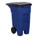 A blue Rubbermaid trash can with black wheels and a black lid.