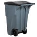 A grey Rubbermaid commercial trash can with wheels and a black lid.
