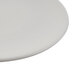 A close-up of a Libbey Driftwood Satin Matte Porcelain Coupe Plate with a small hole in the middle.