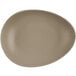A beige Libbey Driftstone porcelain coupe plate with a matte finish and organic texture.