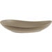 A close up of a Libbey Driftstone Sand Satin Matte porcelain coupe plate with a curved shape.