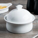 A white Libbey porcelain casserole dish with a lid on a table.