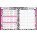 An At-A-Glance planner with a pink cover and floral pattern on the calendar pages.