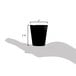 A hand holding a Libbey black shot glass filled with black liquid.