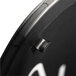 A close-up of a black triangular metal umbrella stand with a white face.