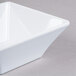 A white square bowl on a gray surface.