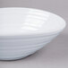 An Elite Global Solutions white oblong melamine bowl on a gray surface.