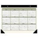 An At-A-Glance desk pad calendar with a black corner and green and white text.