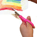 A child's hand cutting a colorful drawing with Westcott blunt tip kids scissors.