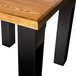 A BFM Seating black square bar height table base on a wooden table in a bar.