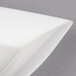 A bright white square china tasting platter with a curved edge.