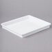 A white square lid for a white melamine tray on a gray surface.