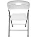 A black folding chair with a white molded resin back and seat.