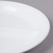 A close-up of an Elite Global Solutions 9 inch white 3-compartment melamine plate.